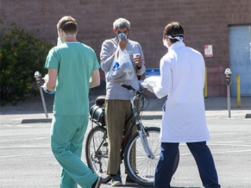 Chris Vance (right) and another College of Medicine – Tucson student offer food, drinks and medical services to the homeless population served at Z Mansion several times a week.