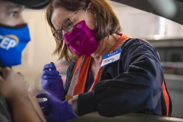 University of Arizona College of Nursing Professor Terry A. Badger, PhD, RN, administers COVID-19 vaccine injections at the drive-through POD at the University of Arizona.