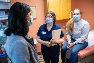 Judith Hunt, MD, (middle) confers with a patient and other health care provider in Payson.