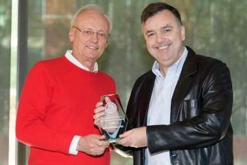 Two men standing and holding glass College of Pharmacy award.