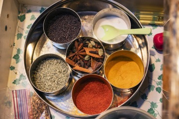 An array of six spices in metal bowls.