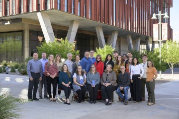 About 20 members of the UArizona Health Sciences Office of Communications stand for a group photo outside of the Health Sciences Innovation Building.