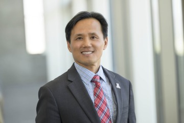 Portrait of Hyochol Brian Ahn smiling while wearing a suit and tie.