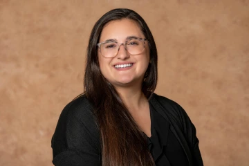 Portrait of Stephanie Schaller, a woman with long dark hair smiling. 