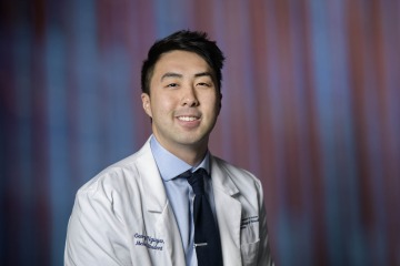 Dr. George Nguyen wearing a College of Medicine – Phoenix white coat