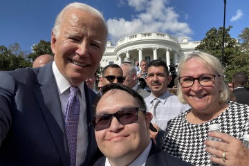 Photo of President Joe Biden with Gabe Martinez and Gabe’s mom with the White House in the background.