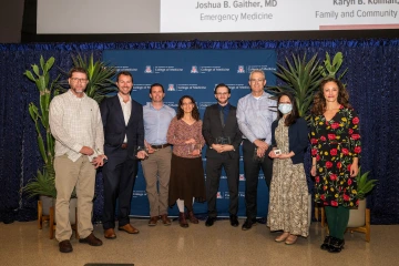 A group of eight College of Medicine – Tucson faculty members poses for a photo after winning awards for mentoring.