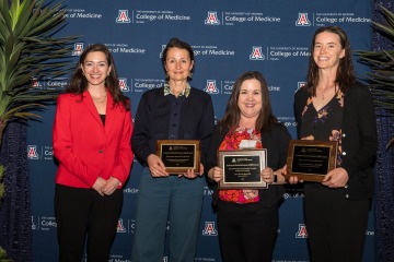 Four smiling College of Medicine – Tucson faculty members pose for a photo after three of them received awards.