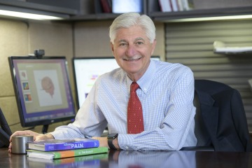 portrait of pain and addiction researcher Frank Porreca sitting at his desk at the University of Arizona Health Sciences