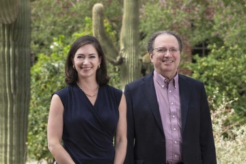 Portrait of researchers Tara Carr, MD, and Fernando Martinez, MD, in front of a Sonoran desert landscape