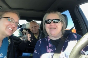 A selfie of three people in a car