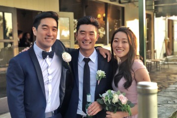 Three siblings pose in front of a restaurant