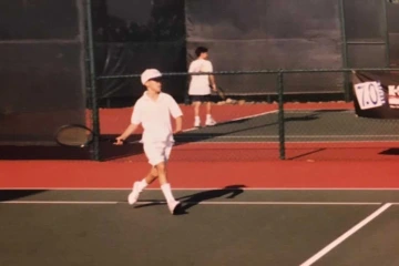 A young Jonathan Lee-Confer playing tennis.