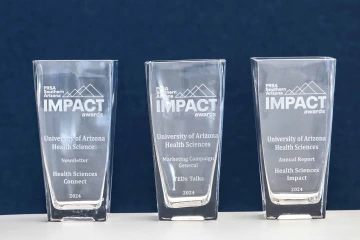 A photo of three Public Relations Society of America – Southern Arizona IMPACT Awards received by the University of Arizona Health Sciences Office of Communications.