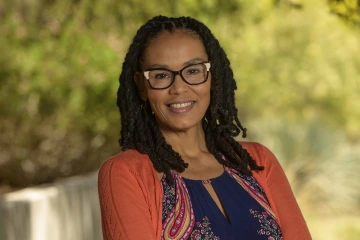 Portrait of Tarnia Newton smiling in an outdoor setting.