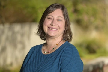 Portrait of Laura Kennicutt smiling in an outdoor setting.