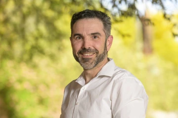 Portrait of Matthew Choate smiling in an outdoor setting.