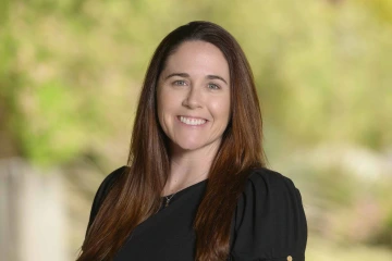 Portrait of Tara Azad smiling in an outdoor setting.
