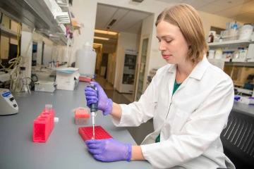 Portrait of Elizabeth Borden using a pipette in a research laboratory