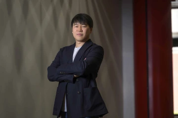 Portrait of faculty member Eungjoo Lee, standing arms crossed