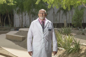 Portrait of Stewart Goldman, MD, standing outside in a doctors white coat.