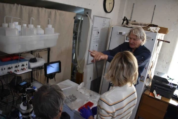 Photo of Stephen A. Klotz, MD, in a lab, talking to two people.