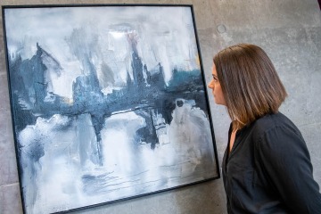 Harriet Barratt, MD, with her painting Fjords, an acrylic spray paint on wood.