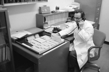 Albert L. Picchioni, PhD, provides a phone consultation using one of 2,000 index cards he created with information on chemicals and their health effects. Dr. Picchioni, professor and acting dean of the college from 1975-1977, created the Arizona Poison Control System, a precursor to the Arizona Poison and Drug Information Center.