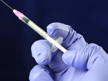 Health worker prepares a Hypodermic needle with Influenza vaccine