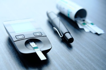 Image of a blood glucose meter, insulin pen and diabetic test strips