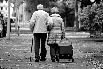 Older couple walking down a sidewalk