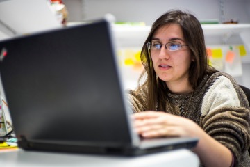 Alise Ponsero, PhD, one of the first Data Science Fellows at the University of Arizona Health Sciences, sitting in front of a laptop computer. 