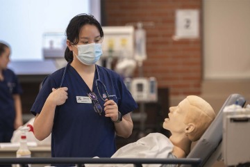 UArizona College of Nursing student Alexa Wong assesses her manikin patient in the simulation lab. 