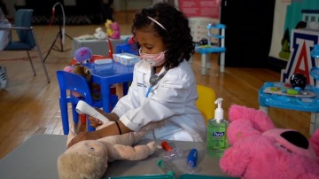 A child gives a teddy bear a checkup at the Wildcat Play Hospital.