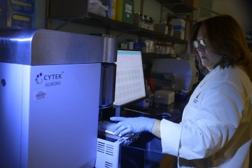 woman in lab working on flow cytometry machine