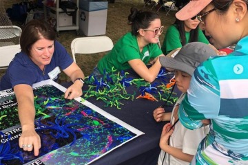 Helena Morrison, PhD, RN, associate professor at the College of Nursing, shows children at the Tucson Festival of Books how they can make brain cells out of pipe cleaners. (Photo courtesy Helena Morrison/Instagram)