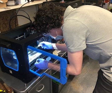 Engineering graduate student Kevin Frederick 3D prints mask components using a filament printer as part of the prototyping process.