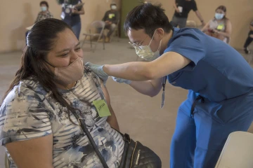 Alvin Wong, DO, a clinical associate professor with the College of Medicine – Phoenix, administers a COVID-19 vaccine to a patient at the community center in Aguila, Arizona, a rural agricultural community west of Phoenix in Maricopa County.