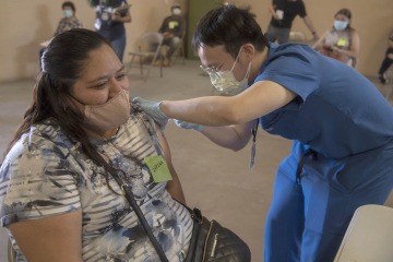 Alvin Wong, DO, a clinical associate professor with the College of Medicine – Phoenix, administers a COVID-19 vaccine to a patient at the community center in Aguila, Arizona, a rural agricultural community west of Phoenix in Maricopa County.