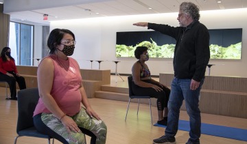 Andrew Belser demonstrates movement techniques from the Feldenkrais Method to a group of students, faculty and staff in the Forum at the Health Sciences Innovation Building.