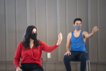 Jennie Greb and Alex Murillo practice a motion stretch, using their eyes to follow their hands. The exercise demonstrates how much further we move when we use all of our body. 