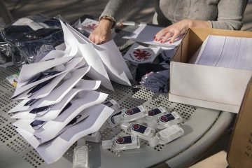 Grad students on the CoVHORT team assemble thank-you packets for study participants outside Drachman Hall.