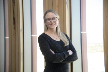 Woman standing with arms folded and smiling