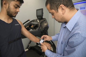 Gustavo de Oliveira Almeida, PhD, coordinator of the Sensor Lab, demonstrates how a wireless wrist sensor can be fitted to gather data for research purposes.