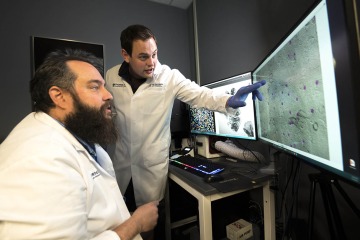 Two male researchers looking at a computer screen