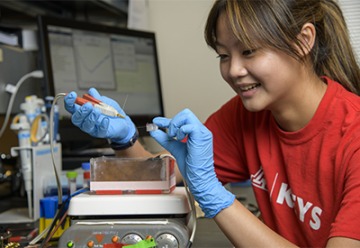 High school student Yi-Jen Yang works on a device that tests whether blood has functioning platelets that can properly aggregate and coagulate. 
