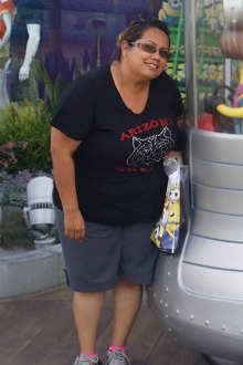candid photo of Tina Teran standing next to a minion statue at a theme park 