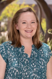 Portrait of Kathryn Emerick outside in front of a sculpture