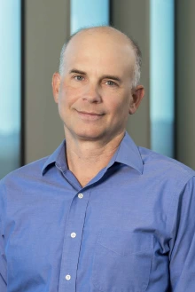 Portrait of Michael Kuhns, PhD, indoors in front of windows