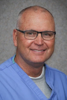 Portrait of Ken Johnson, MD, in blue scrubs
